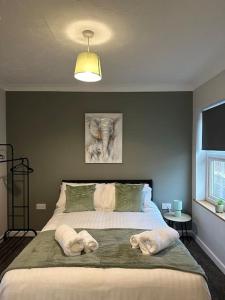 a bedroom with a large bed with two dogs on it at Walnut House - Modern 1 Bedroom Apartment very close to town by Shortstays4u in Kings Lynn