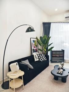 a living room with a black couch and a table at Fivehouse Silom1 - City heart - Silom -BTS MRT 2min - lumpini park - bnh in Bangkok