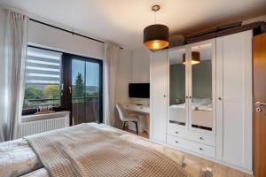Un dormitorio con una cama y un escritorio y una ventana. en 2-Zimmer Ferienwohnung Am Waldrand, en Schönwald