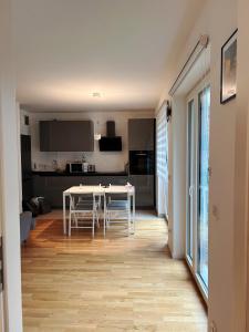 a kitchen and living room with a white table and chairs at City Nest Offenbach in Offenbach +20 photos