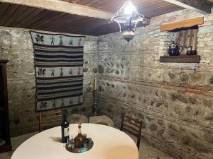 a table and chairs in a room with stone walls at Hotel Tao in Telavi