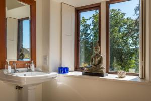 a bathroom with a sink and a statue in a window at Bank Barn, Wreay in Penrith +54 photos