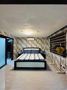 1 dormitorio con 1 cama en una habitación con paredes de piedra en Executive Staycation, en Ángeles