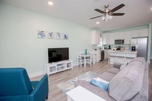 a living room with a couch and a tv at Bluebird By The Sea in Gulfport