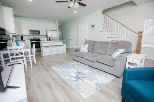 a living room with a couch and a kitchen at Bluebird By The Sea in Gulfport