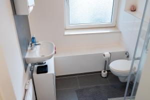 une salle de bain avec toilettes, lavabo et fenêtre dans l'établissement Business Apartment 5 Essen, à Essen