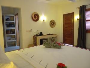 a bedroom with a bed with two teddy bears on it at Aluna Beach House Nungwi in Nungwi +13 photos