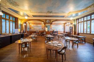 a restaurant with tables and chairs and a ceiling at Hôtel Arc en Ciel et SPA Les Sables d'Olonne in Les Sables-d'Olonne