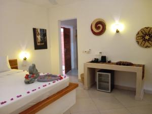 a bedroom with a bed and a fireplace and a clock at Aluna Beach House Nungwi in Nungwi