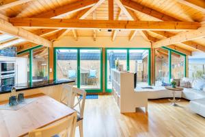 cocina y sala de estar con techos y ventanas de madera. en Schöne Fewo mit Badewanne, geschützter Dachterrasse und WLAN, en Heringsdorf