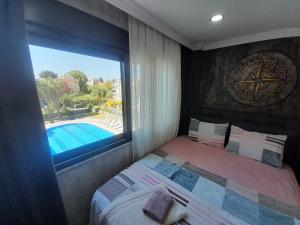 锡德Side By Lotus的一间卧室设有一张床,窗户设有游泳池