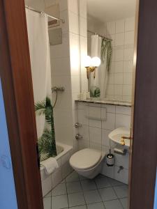 a white bathroom with a toilet and a sink at Estelada Boarding Houses Zorneding in Zorneding