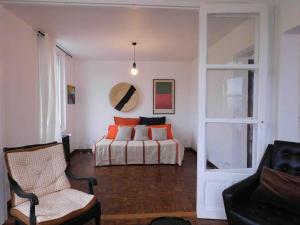 a bedroom with a bed with orange pillows and a chair at 10 Courchamp in Courchamp