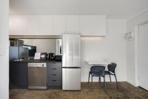 a kitchen with a refrigerator and two chairs at Fly Around Town in Chic Retreat in Albion