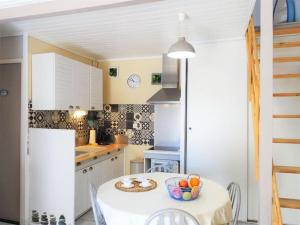 a kitchen with a table with a bowl of fruit on it at Pavillon proche plage in Narbonne +17 photos