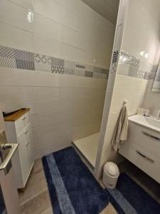 a white bathroom with a sink and a toilet at Pavillon proche plage in Narbonne