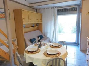 a dining room table with a white table cloth and wine bottles at Pavillon proche plage in Narbonne
