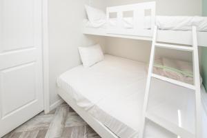 a small bedroom with a bunk bed and a ladder at Blufin Bungalows & Marina in Chincoteague
