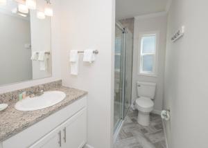 a bathroom with a sink and a toilet at Blufin Bungalows & Marina in Chincoteague +25 photos