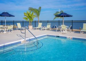 ein Swimmingpool mit Stühlen und Sonnenschirmen in der Unterkunft Blufin Bungalows & Marina in Chincoteague