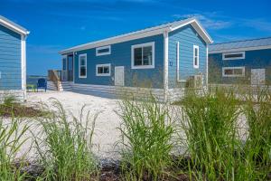 ein blaues Haus am Strand neben dem Meer in der Unterkunft Blufin Bungalows & Marina in Chincoteague