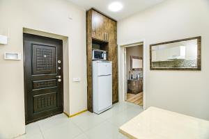 a kitchen with a black door and a refrigerator at Little Gem in the Old City - One Bedroom in Baku