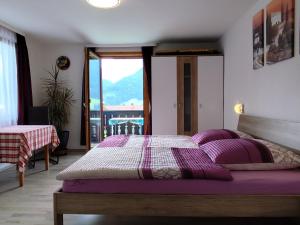 a bedroom with a bed with purple pillows and a window at Bad Hindelang in Bad Hindelang