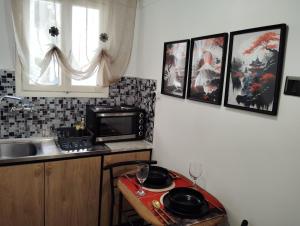 a kitchen with a sink and a table with pots and pans at Tiny Japan in Volos
