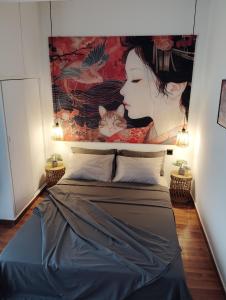 a bed with a painting of a woman and a cat at Tiny Japan in Volos
