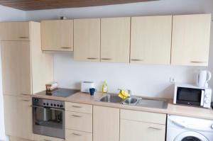 a kitchen with white cabinets and a sink and a microwave at Zentrales Wohnhaus Ichenhausen in Ichenhausen