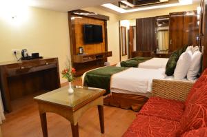 a hotel room with a bed and a couch at Benzz Park Family Resort Kodaikanal in Kodaikānāl