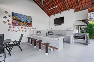 a kitchen with a counter and chairs and a tv at Villa with Pool, Gated Playas del Coco Getaway in Coco
