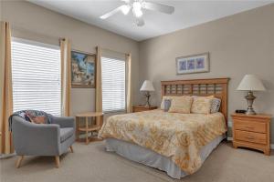 a bedroom with a bed and a chair and windows at Enjoy my cozy house next to Disney in Kissimmee