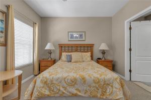 a bedroom with a bed and two tables and two lamps at Enjoy my cozy house next to Disney in Kissimmee +3 photos