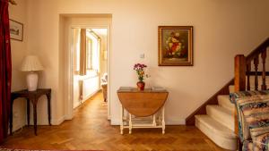 a hallway with a table with a vase of flowers on it at Arlington House in Lower Slaughter