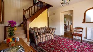a living room with a couch and a staircase at Arlington House in Lower Slaughter