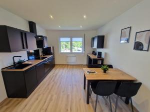 a kitchen with a wooden table and a wooden floor at Ferienwohnung am See - Obergeschoss - Ruhige Lage - Eigener Garten in Borken