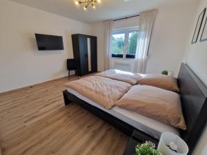 a bedroom with a large bed and a television at Ferienwohnung am See - Obergeschoss - Ruhige Lage - Eigener Garten in Borken