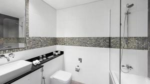 a bathroom with a toilet and a sink and a shower at The First Collection Dubai Marina in Dubai