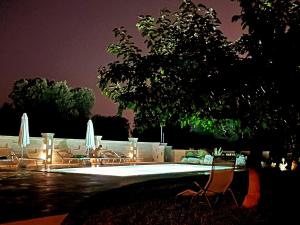 a group of chairs and a pool at night at La casa nel villaggio in Montalbano +32 photos