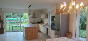 a kitchen with a chandelier hanging over a counter at Le Cabinet-Charmante maison avec terrain in Châtillon-sur-Seine
