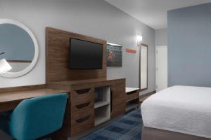a hotel room with a bed and a flat screen tv at Hampton Inn Russellville in Russellville