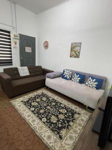 a living room with a couch and a rug at D'inaa Homestay Kota Bharu in Kota Bharu