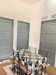 a dining room with a black and white table and chairs at D'inaa Homestay Kota Bharu in Kota Bharu