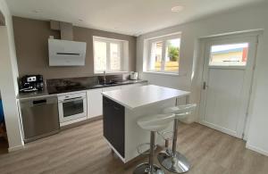 a kitchen with a counter and stools in it at Saint-Pol family house garden fully equipped 12 people in Saint-Pol-de-Léon