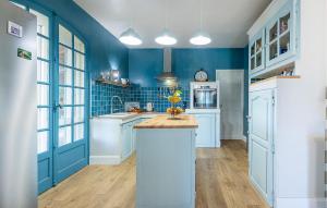 a kitchen with blue walls and white cabinets at 5 Bedroom Cozy Home In Laurens in Laurens +24 photos