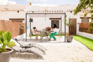 a woman and child sitting at a table on a patio at Casa Cueva Luna in Orce