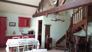 a room with a staircase and a kitchen with red cabinets at La Vallée du Cher in Monthou-sur-Cher