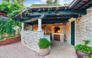 un edificio in pietra con una cucina all'aperto in un cortile di Pet Friendly Home In Supetar With House Sea View a Supetar (San Pietro di Brazza) Altre 27 foto