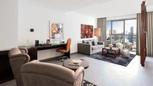 a living room with a desk and a living room with a view at The First Collection Dubai Marina in Dubai